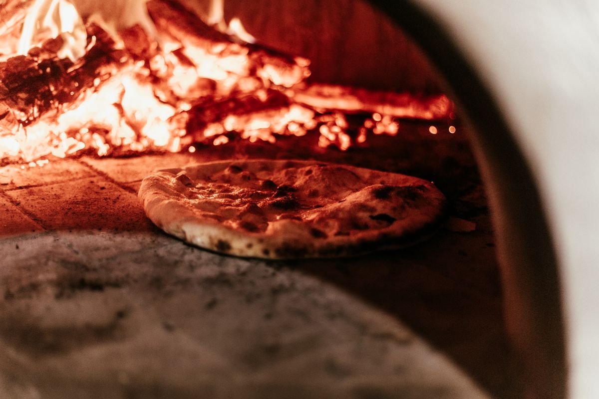 Close-up of a pizza baking in the wood fire